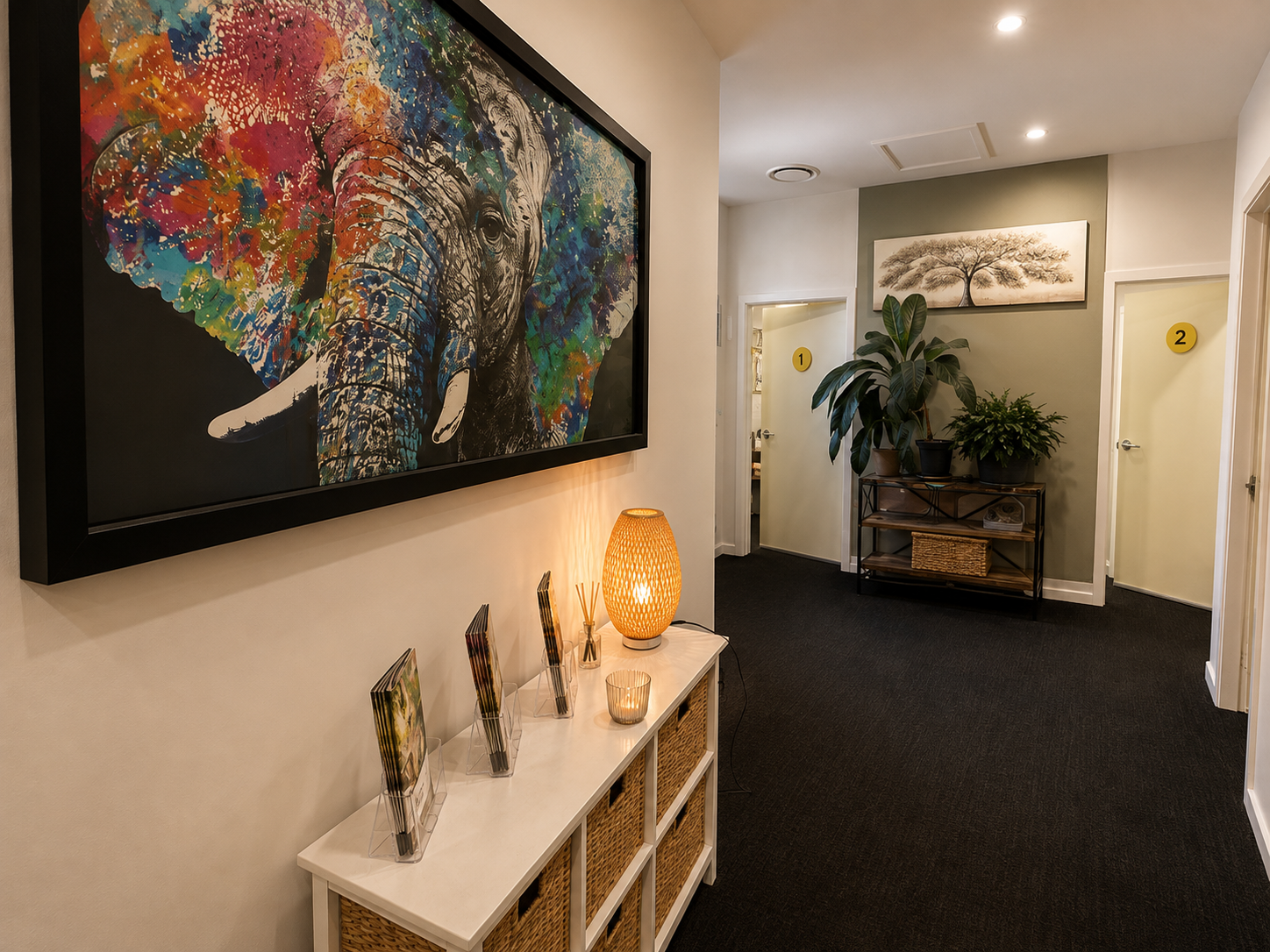 A softly lit hallway with a colourful elephant artwork and a display of wellbeing brochures